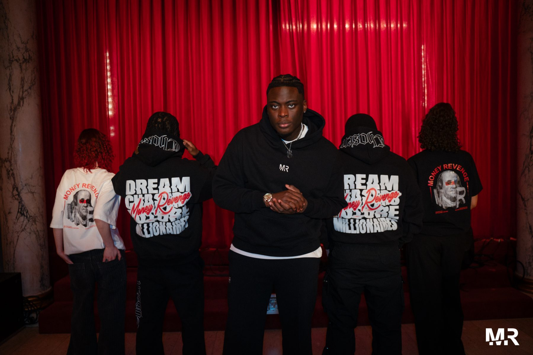 Five models in front of a red theatre curtain, back prints on show