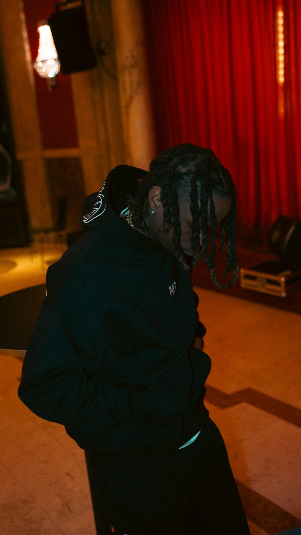 Model in a Money Revenge hoodie in front of the red curtain
