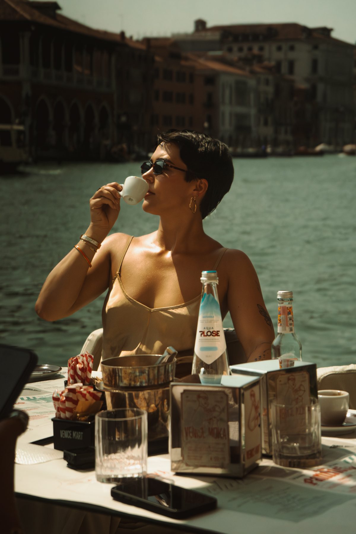Model with an espresso at a table on the Grand Canal